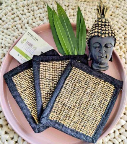 Vetiver coaster handcrafted from natural vetiver roots, part of nature eco products, arranged with green leaves on a soft pastel background.
